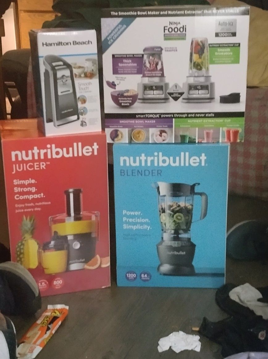 Czerwony blender Nutri Bullet z kubkami smoothie i akcesoriami na stole