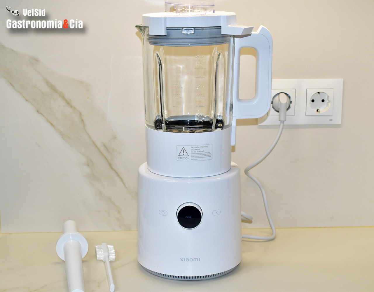 Bateria blendera Xiaomi Smart z ładowarką bateria i ładowarka blendera Xiaomi Smart obok urządzenia