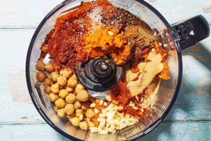 kremowy hummus w misce z oliwą, ciecierzycą i płaskim chlebem na stole