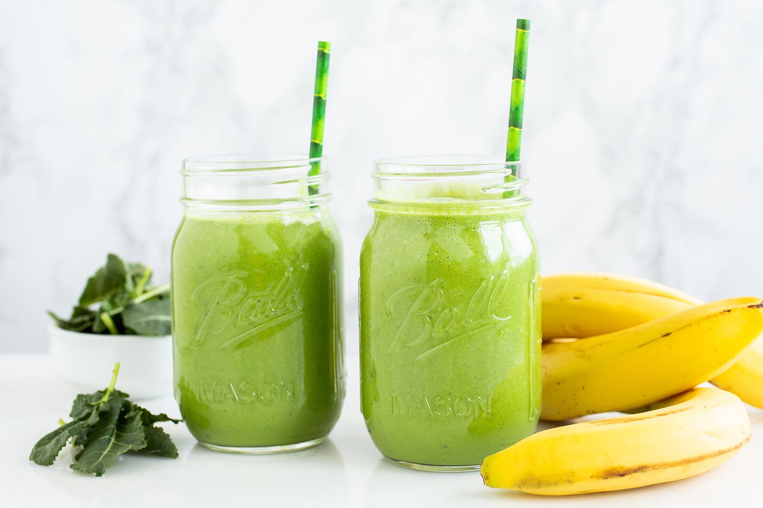 Zielony koktajl jarmużowy z bananem kremowy koktajl z jarmużu bananem i szpinakiem na stole