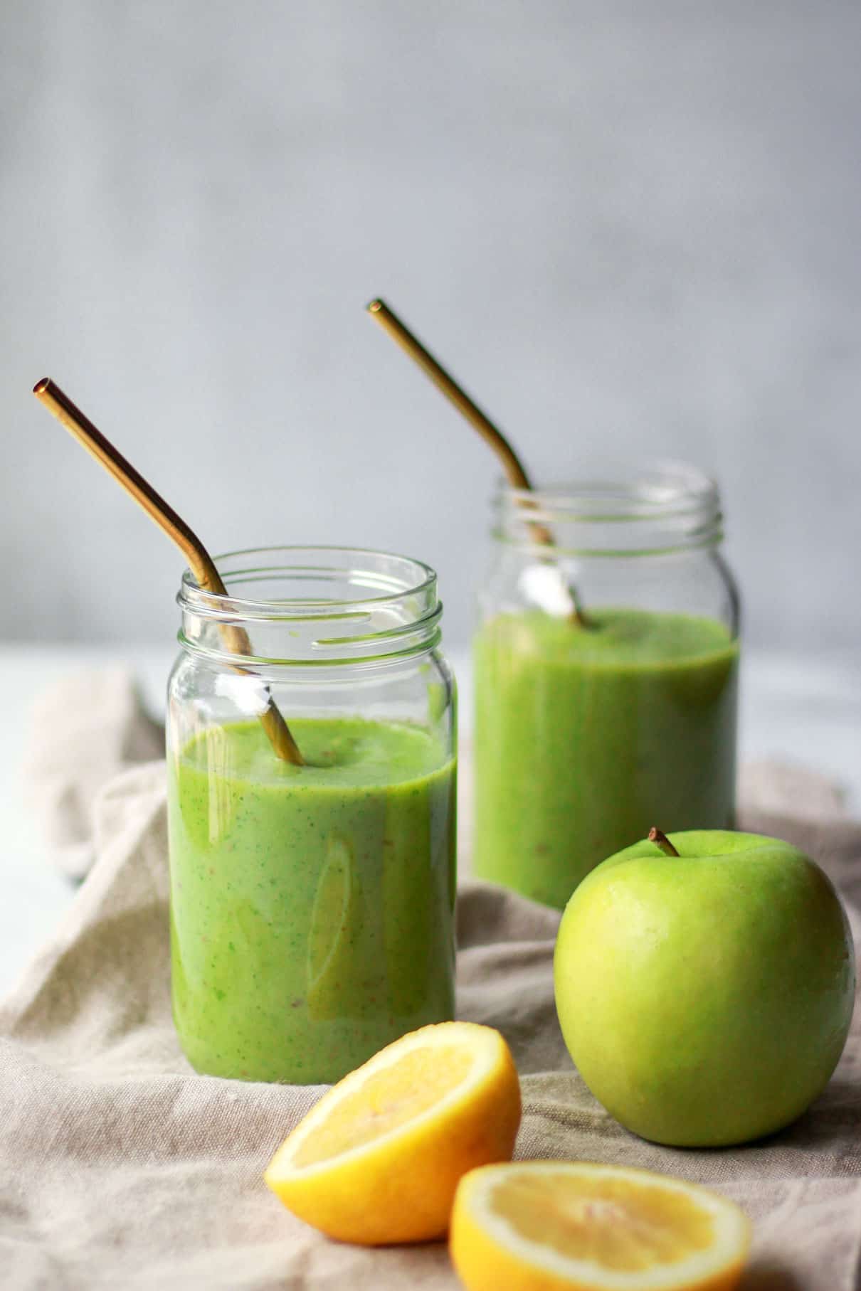Zielony smoothie z jarmużem gotowy do picia zielony koktajl z jarmużu w szklance z łyżką