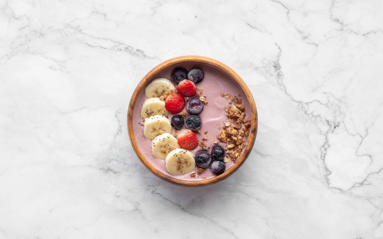 ręce wsypujące erytrytol do blendera z pokrojonymi truskawkami