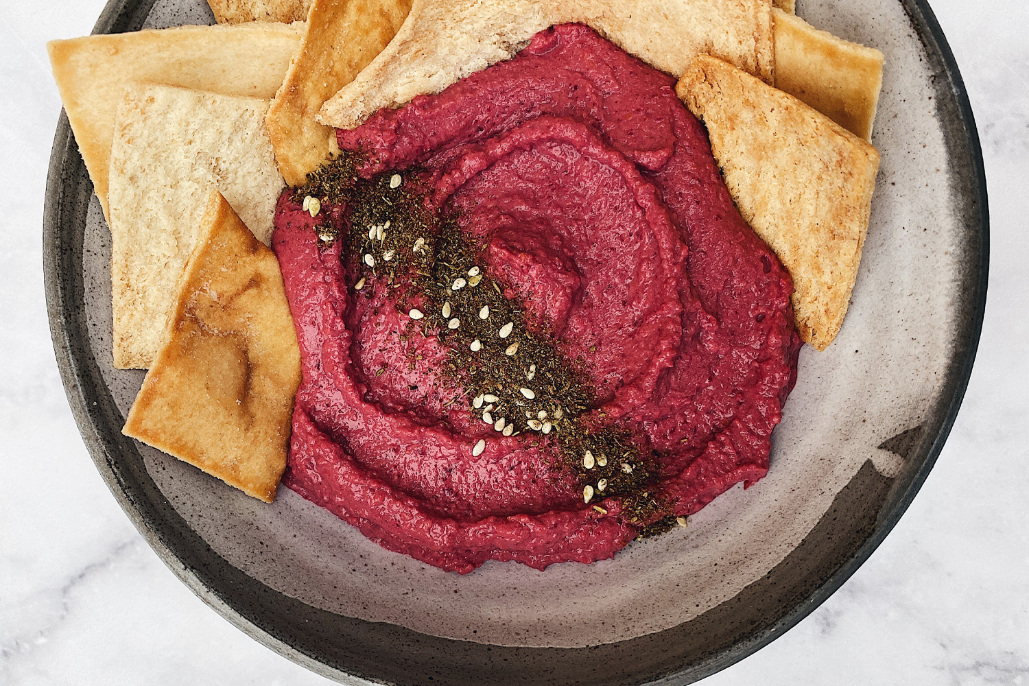 suche ziarna ciecierzycy wsypane do szklanej miski na kuchennym blacie